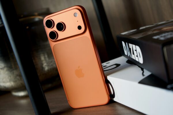 Photo by Georgiy Lyamin Orange smartphone with triple camera system.
